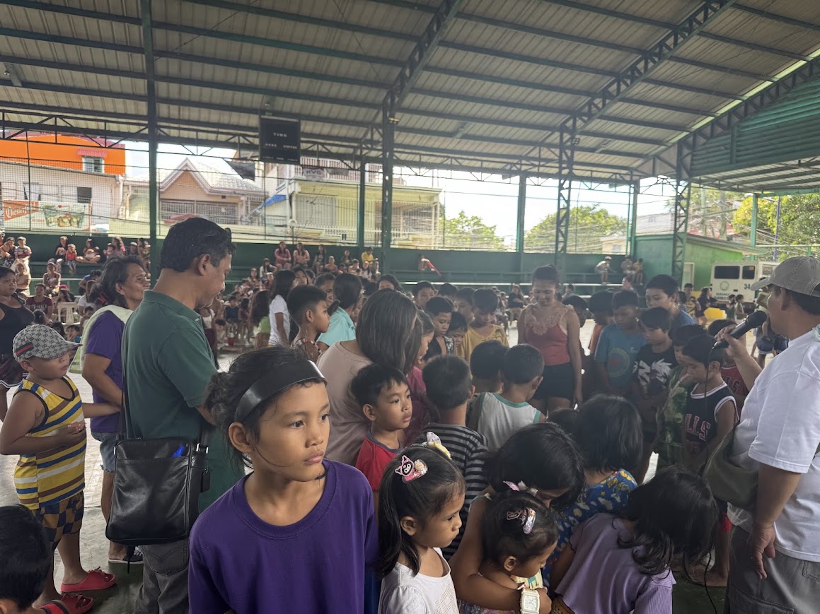 Surrounded by children, a team member leads from the middle of the crowd.