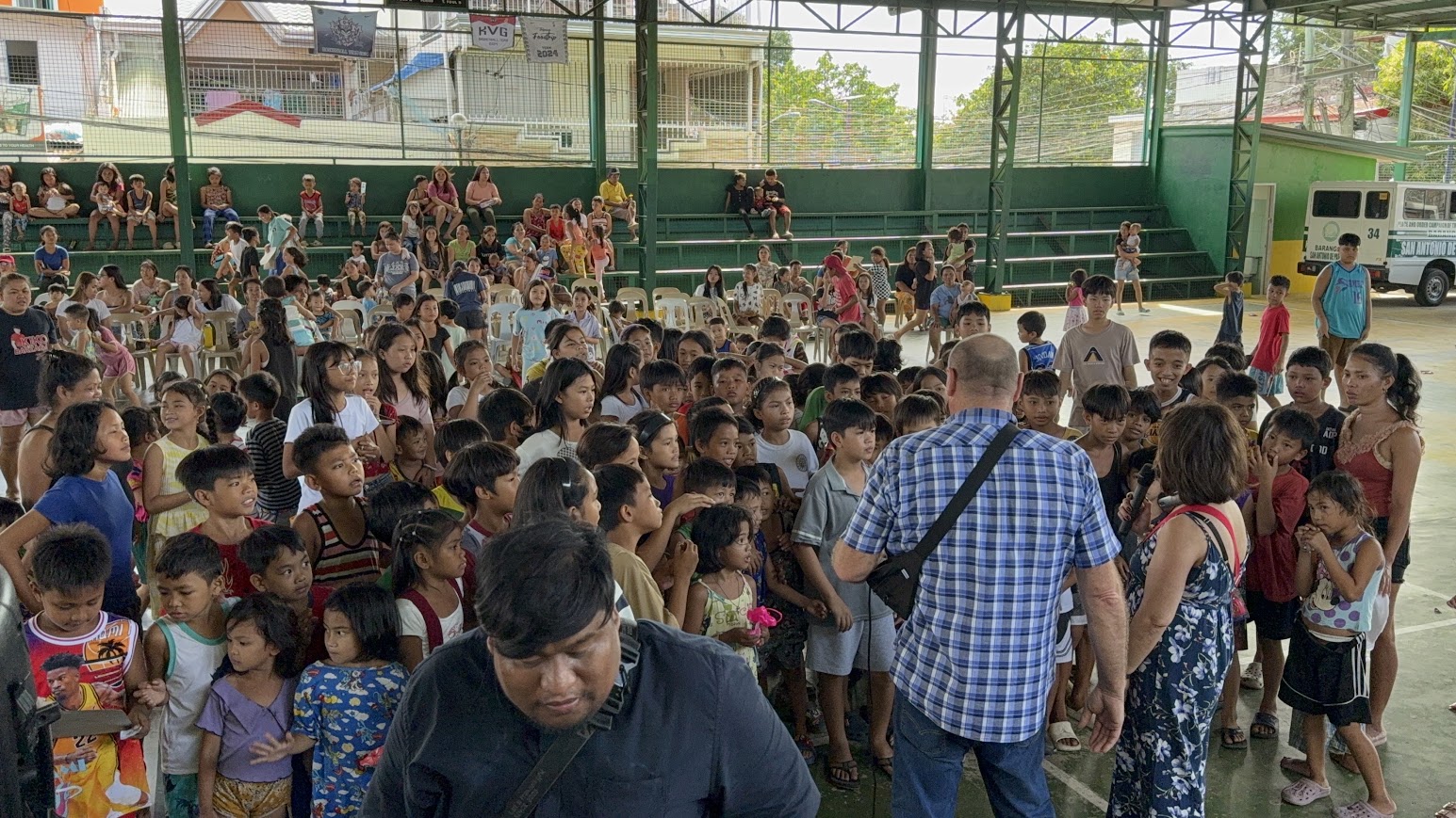 Children line up in a wide row across the court for a game.