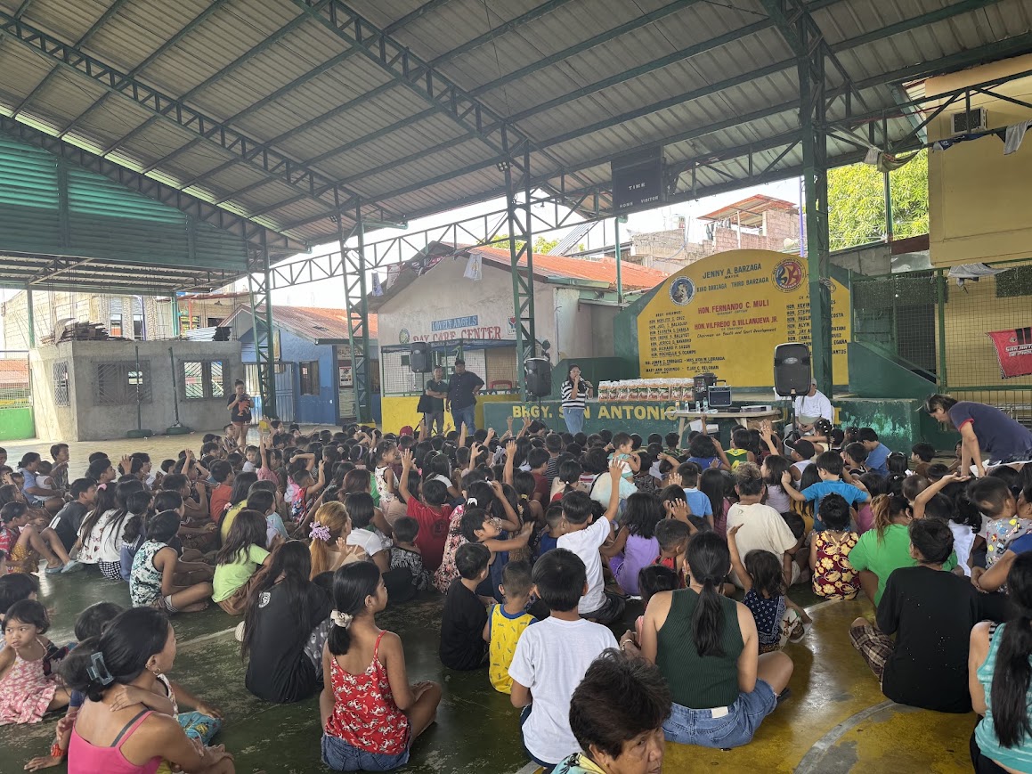 Hands go up across the court beneath the barangay name on the wall.