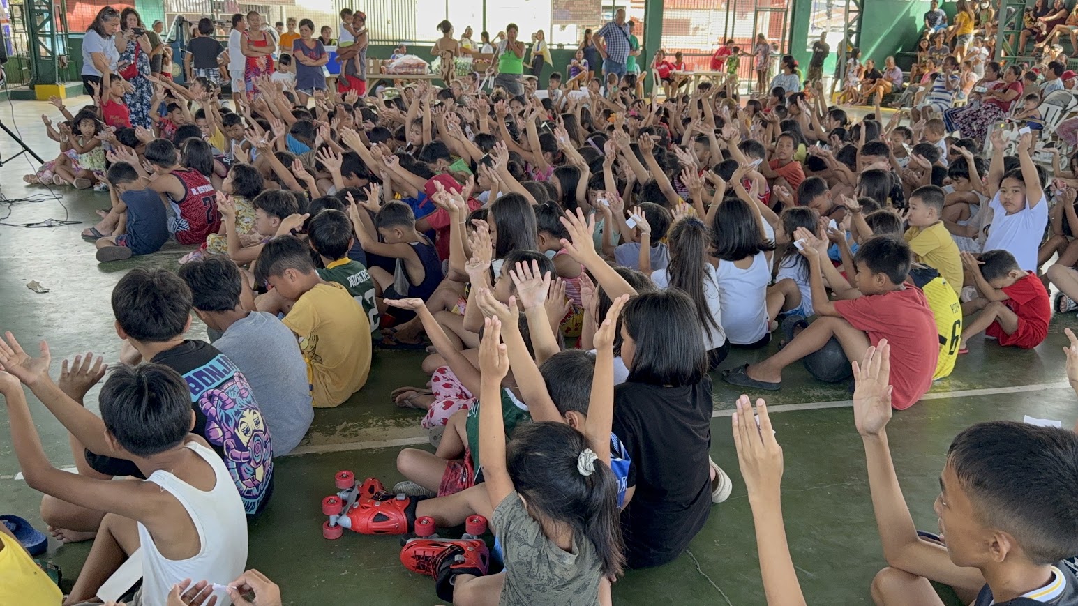 A sea of raised hands seen from behind the crowd.