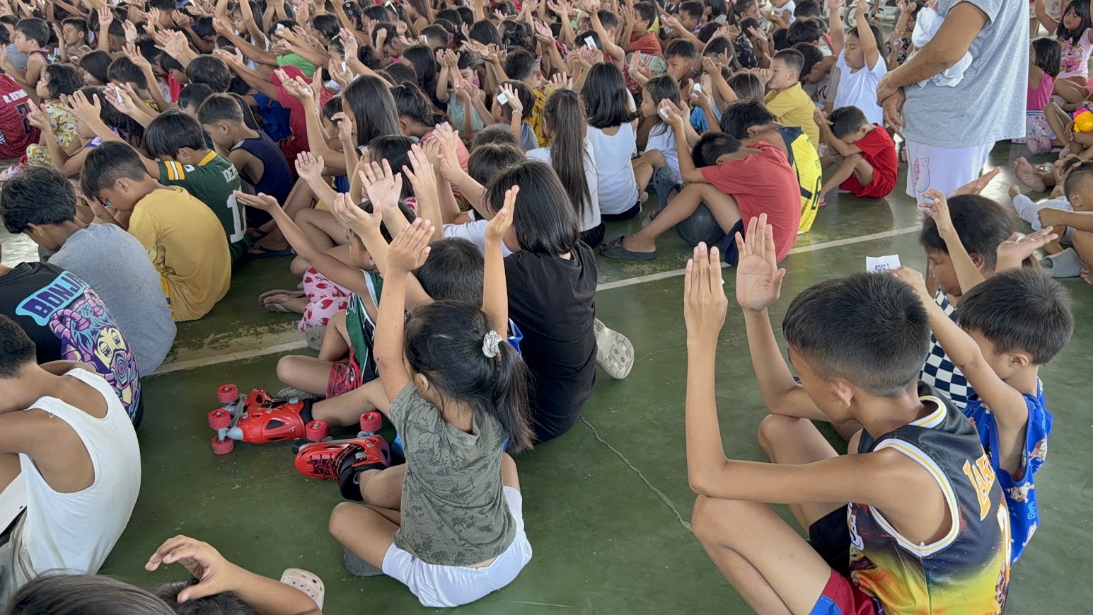 A team member moves through the crowd, a hand resting on a child's head.