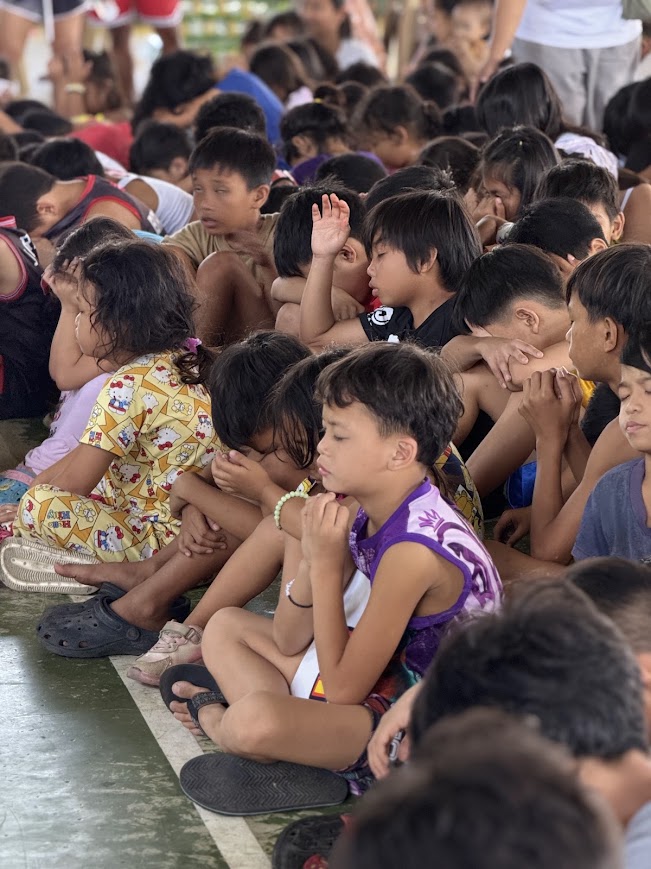 Two young children side by side in prayer.