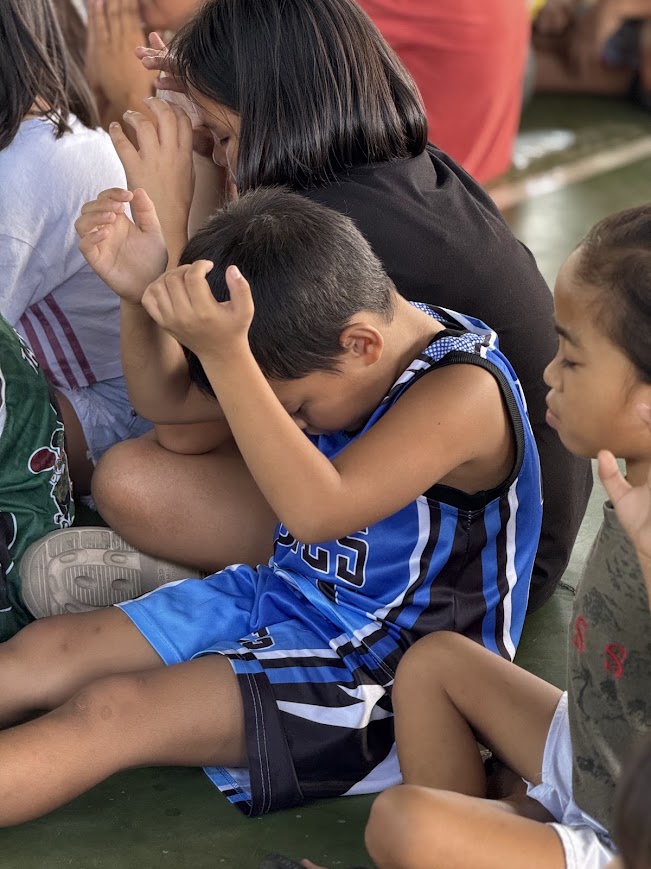 A boy with his head buried in his arms.