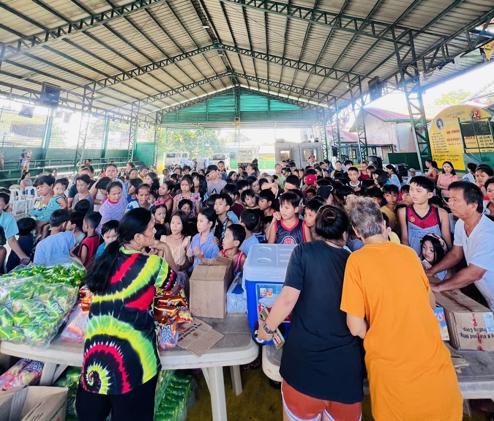 The distribution table — snacks, boxes, and an icebox as the crowd gathers.